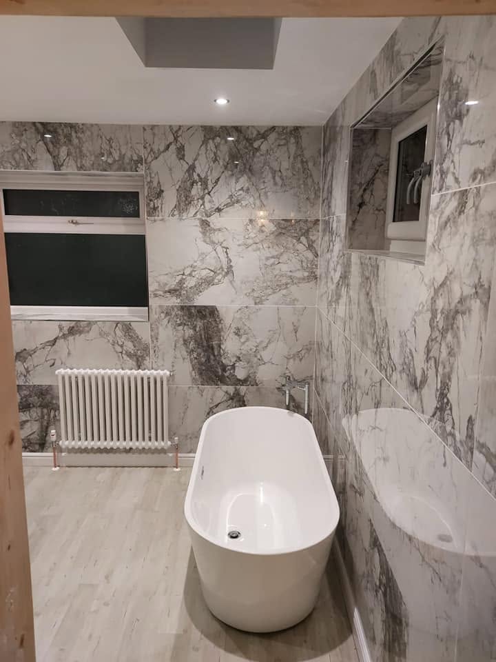 Luxury freestanding bath with marble-effect tiles and column radiator