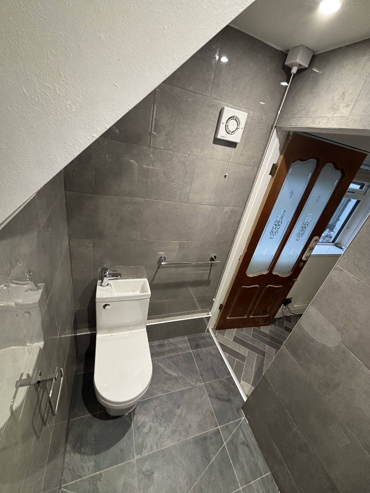 Compact cloakroom with grey tiles and modern toilet