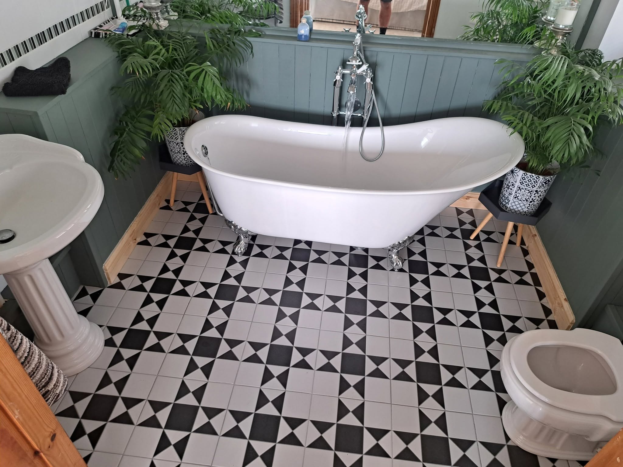 Traditional freestanding bath with black and white geometric floor tiles
