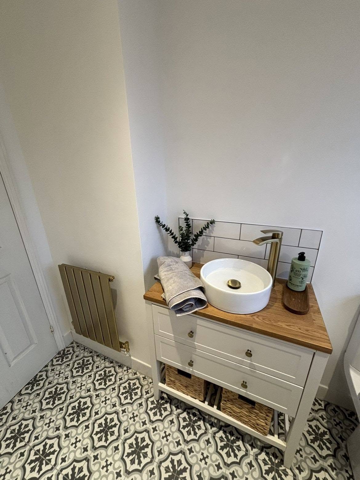 Brass heated towel rail and vanity unit with countertop basin