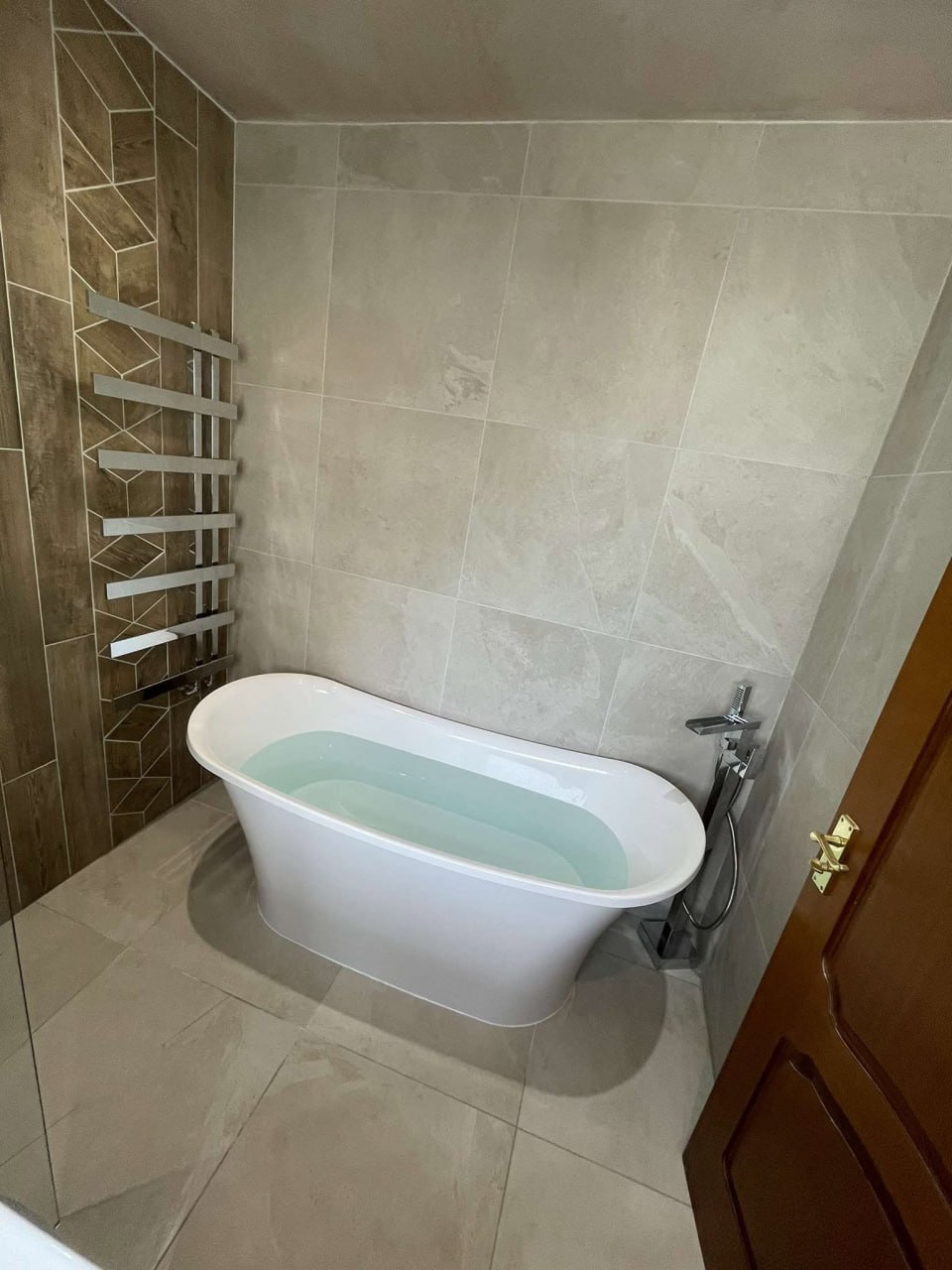 Freestanding bath with heated towel rail